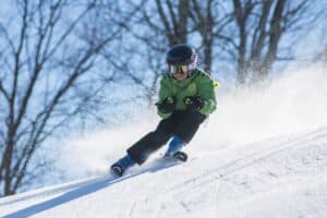 A man riding a snowboard down a snow covered slope