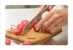 A wooden cutting board, with Santoku