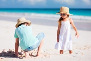 A couple of people that are standing in the sand on a beach