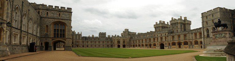 A castle with a clock tower in front of a building