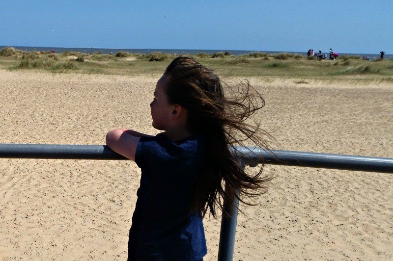 A little girl standing in front of a beach