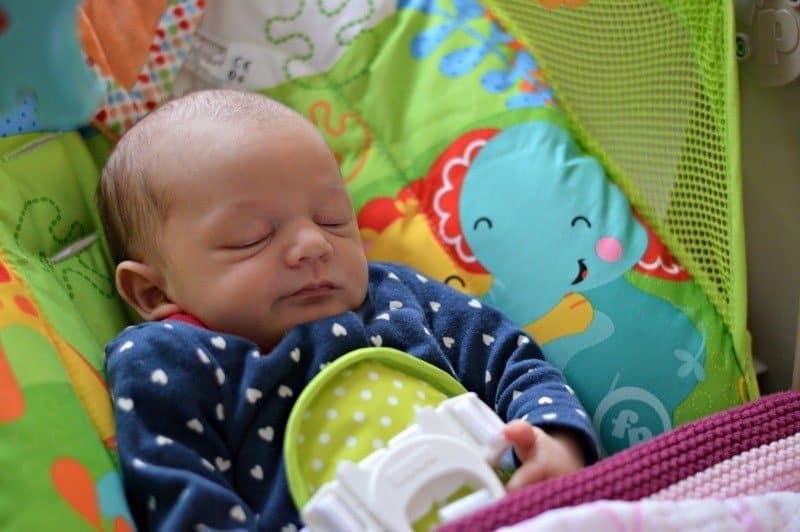 A baby sitting on a bed