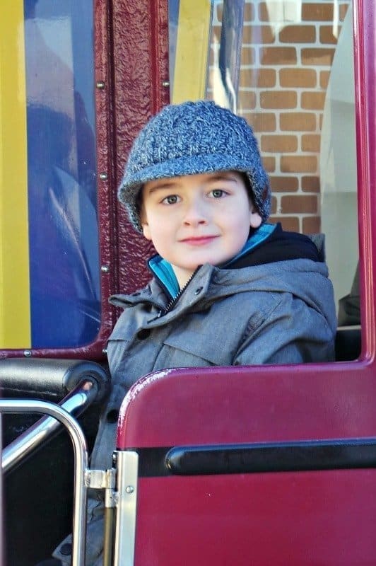 A little boy sitting on a suitcase