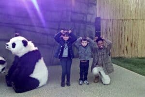 A group of people standing in front of a stuffed animal