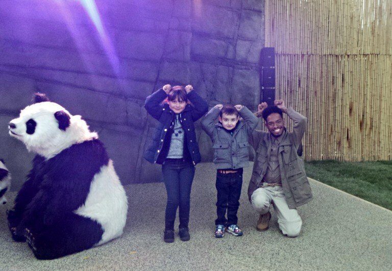 A group of people standing in front of a stuffed animal