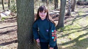 A person standing next to a tree