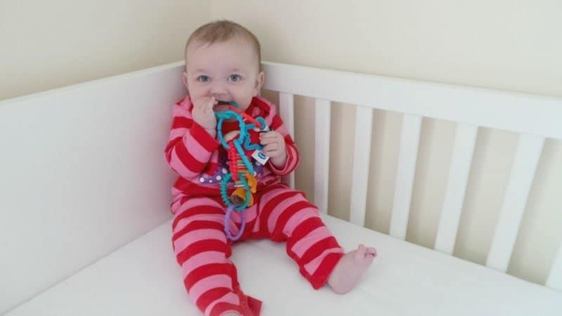 A small child sitting on a bed