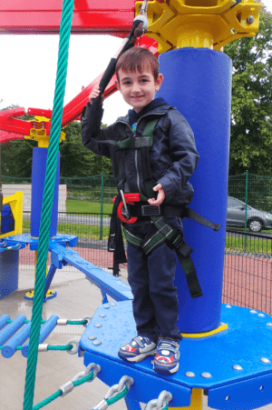 A little boy standing in front of a playground