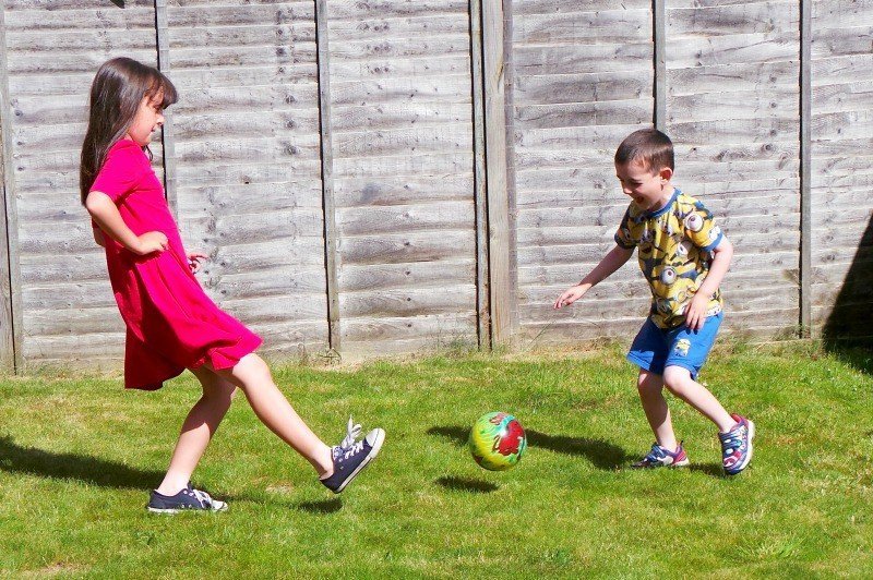 A little girl playing with a football ball