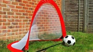 A close up of a football ball in front of a brick building