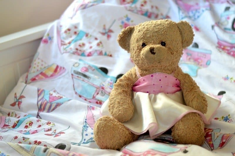 A teddy bear sitting on top of a bed