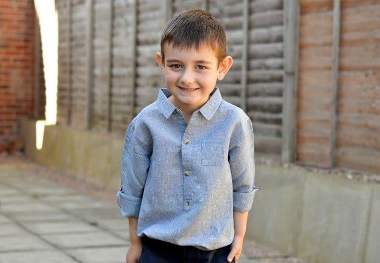 A little boy standing in front of a building