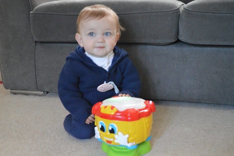 A little boy sitting in a chair holding a baby