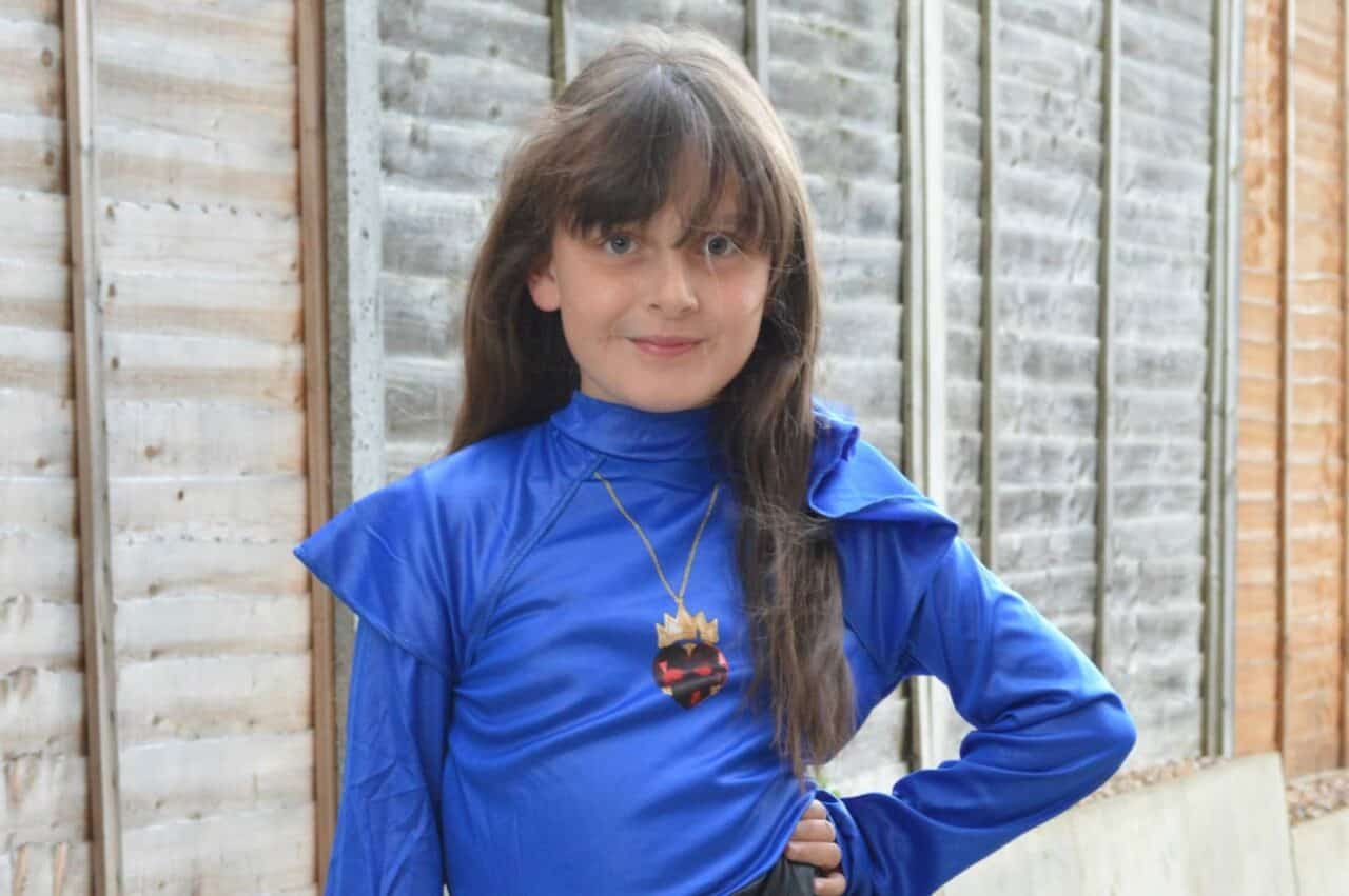 A person wearing a blue shirt standing in front of a building