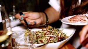 A person sitting at a table with a plate of food