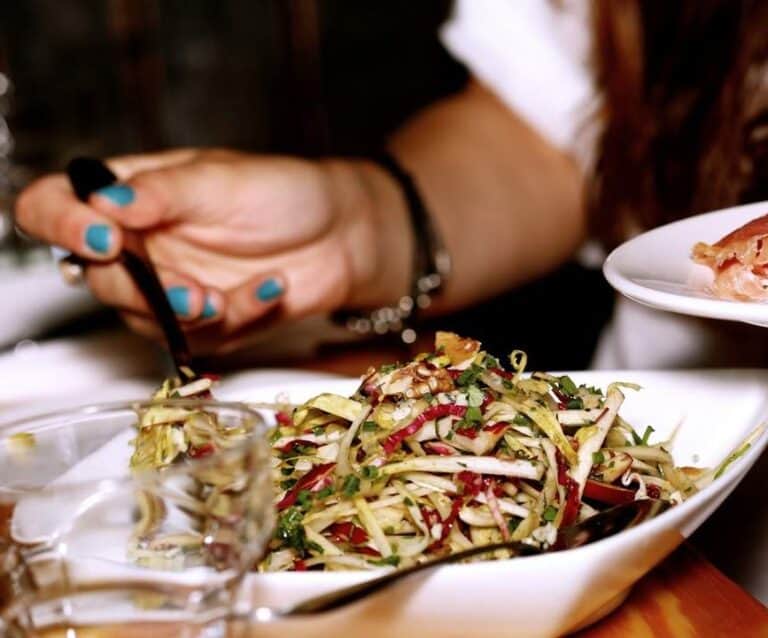 A person sitting at a table with a plate of food