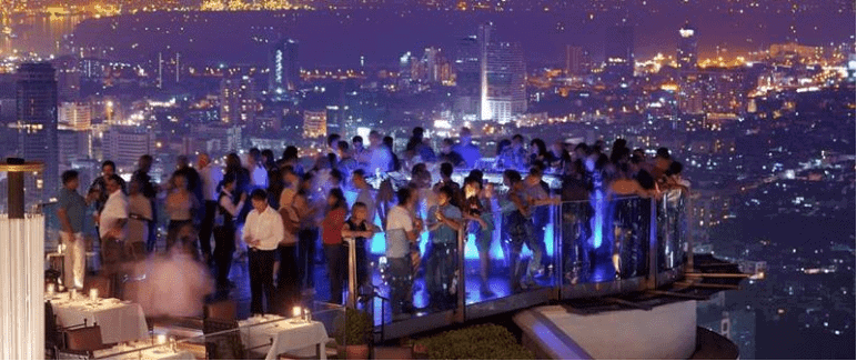 A group of people sitting at a table in front of a building