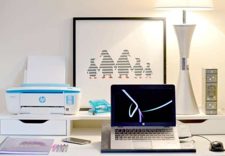 A desk with a laptop computer sitting on top of a table