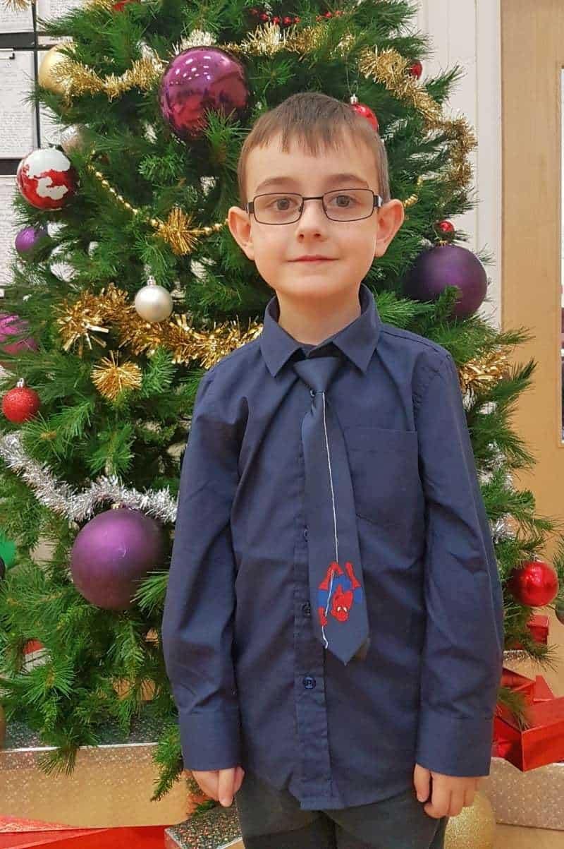 A little boy standing in front of a flower