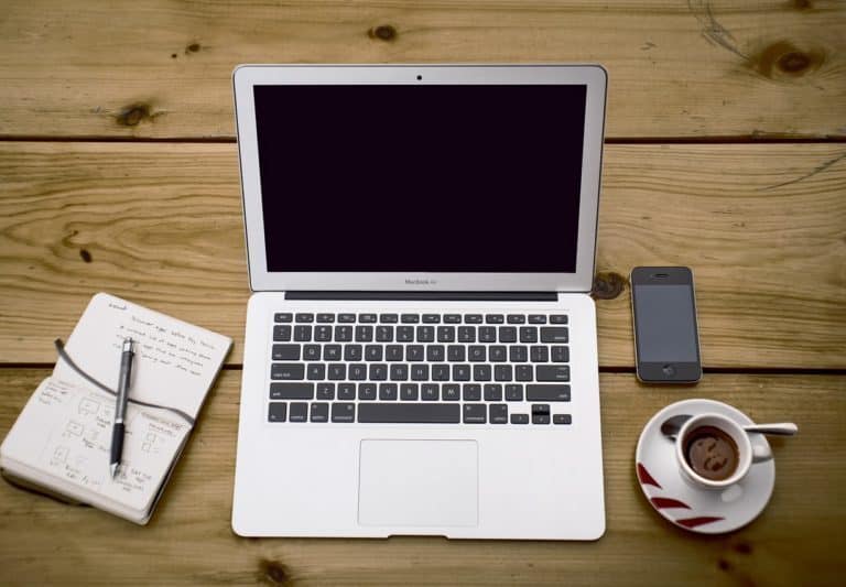 A laptop computer sitting on top of a wooden table