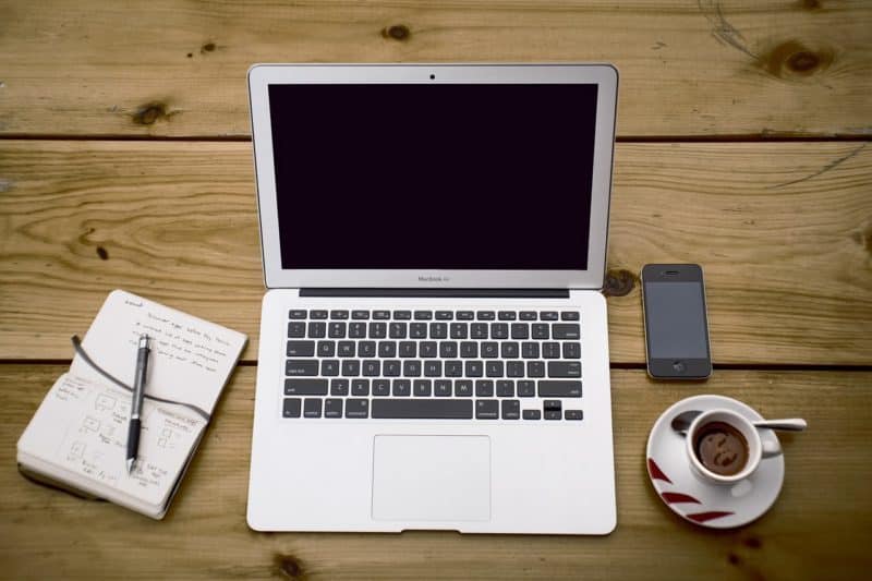 A laptop computer sitting on top of a wooden table