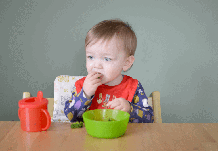 A little boy sitting at a table eating food