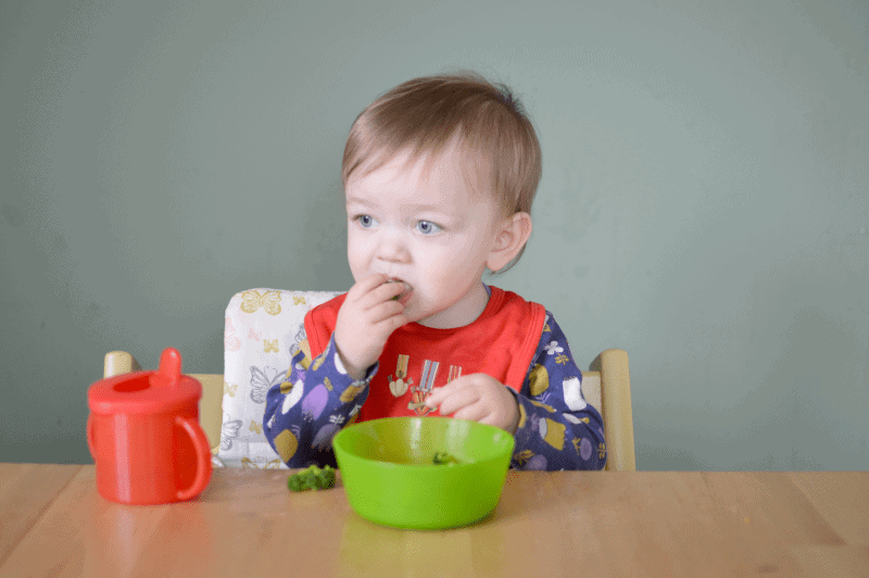 A little boy sitting at a table eating food