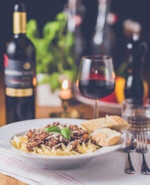 A plate of food and a bottle of wine on a table, with Dinner