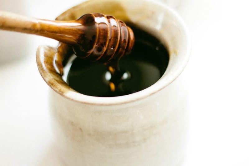 A close up of a coffee cup, with Honey and Sugar