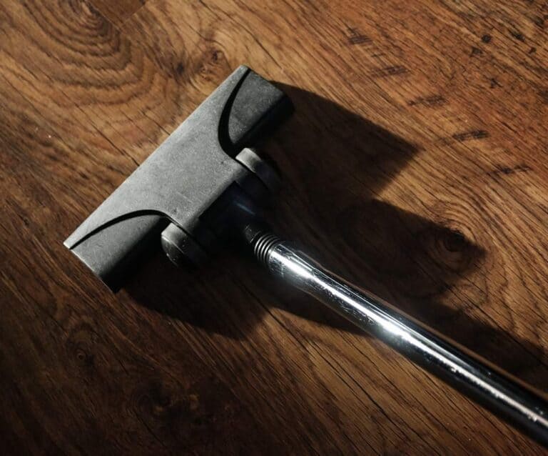 A knife sitting on top of a wooden cutting board, with Cleaner and Vacuum