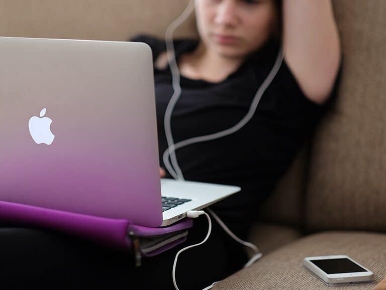 A person sitting at a table using a laptop computer