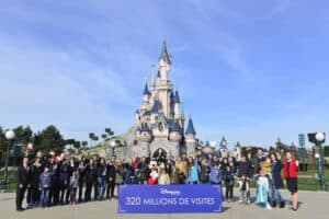 A group of people standing in front of a crowd with Disneyland Paris in the background