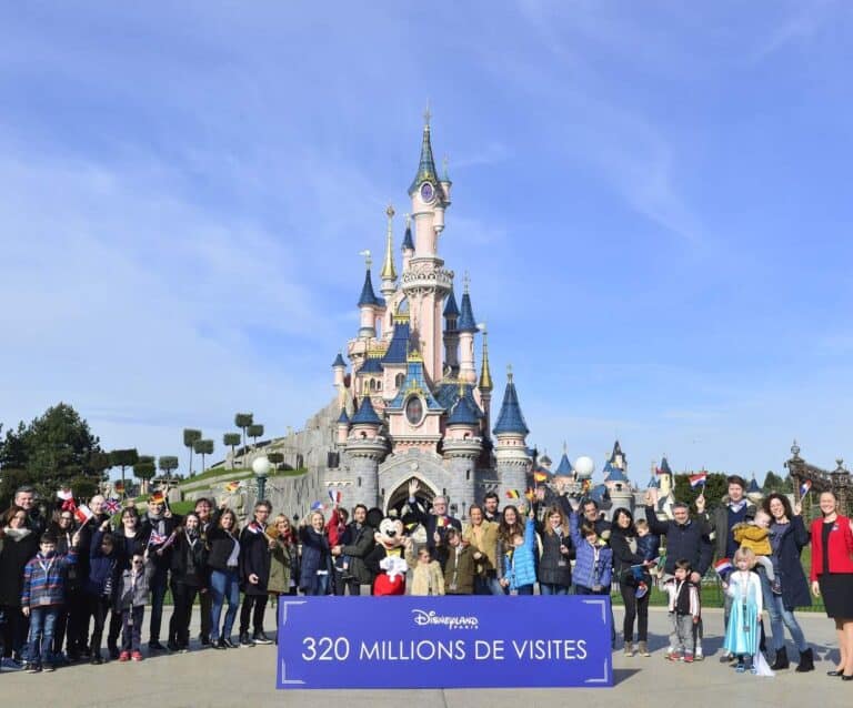 A group of people standing in front of a crowd with Disneyland Paris in the background