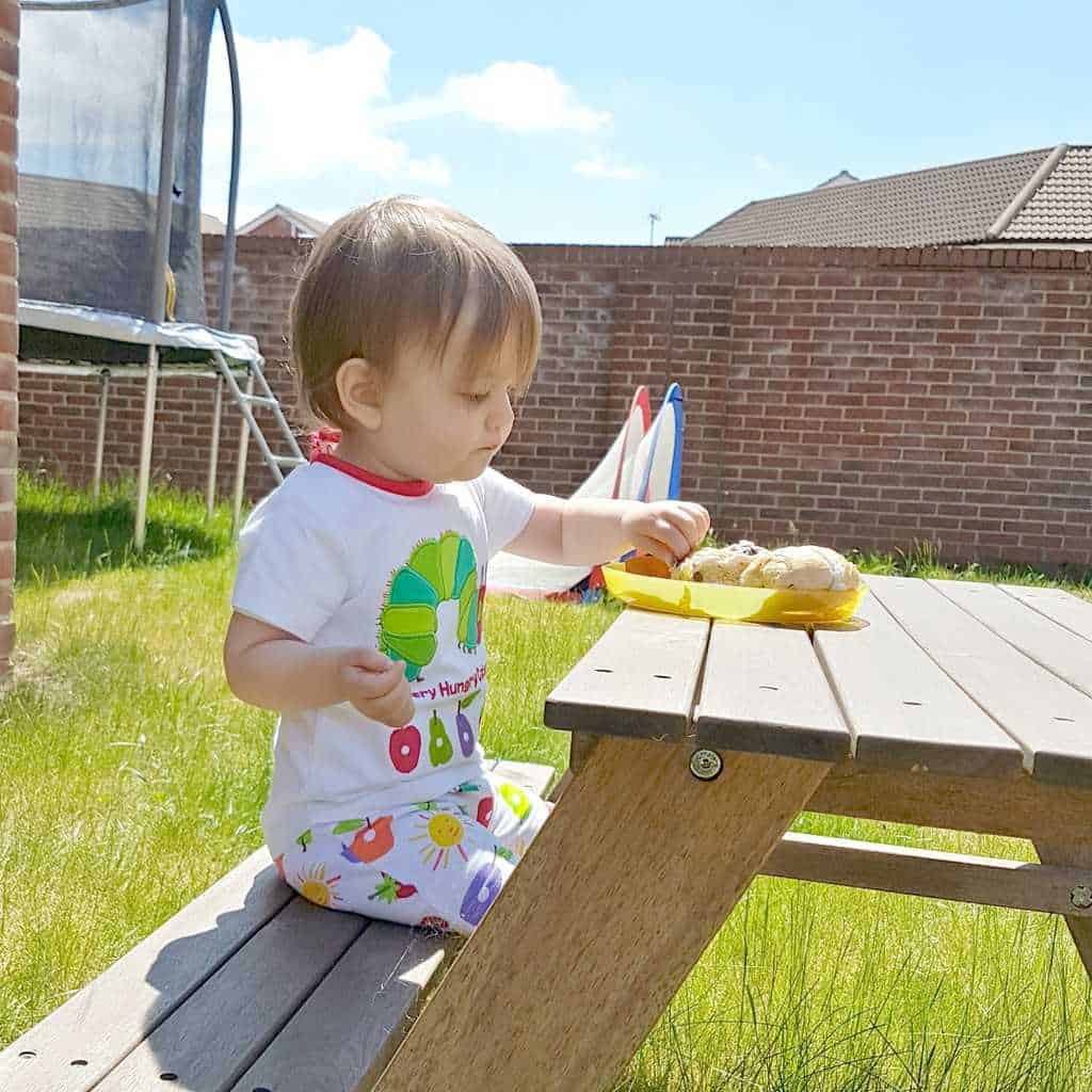 A little boy sitting at a picnic table