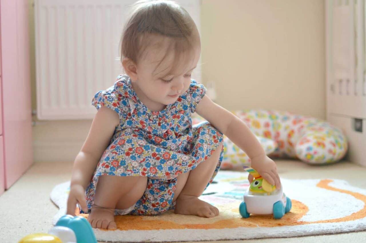 A little girl sitting in front of a baby