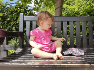 A little girl sitting on a bench