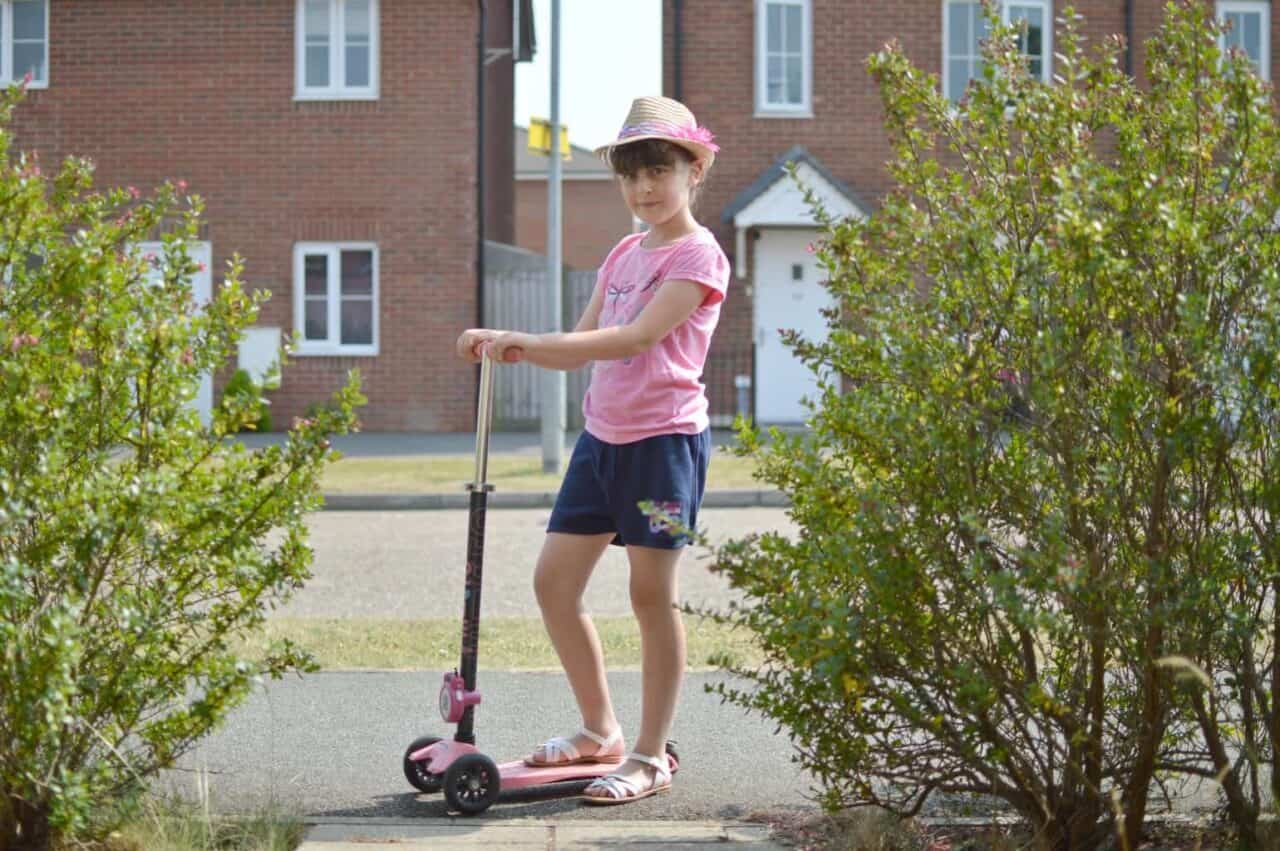 A young girl riding a skateboard up the side of a building