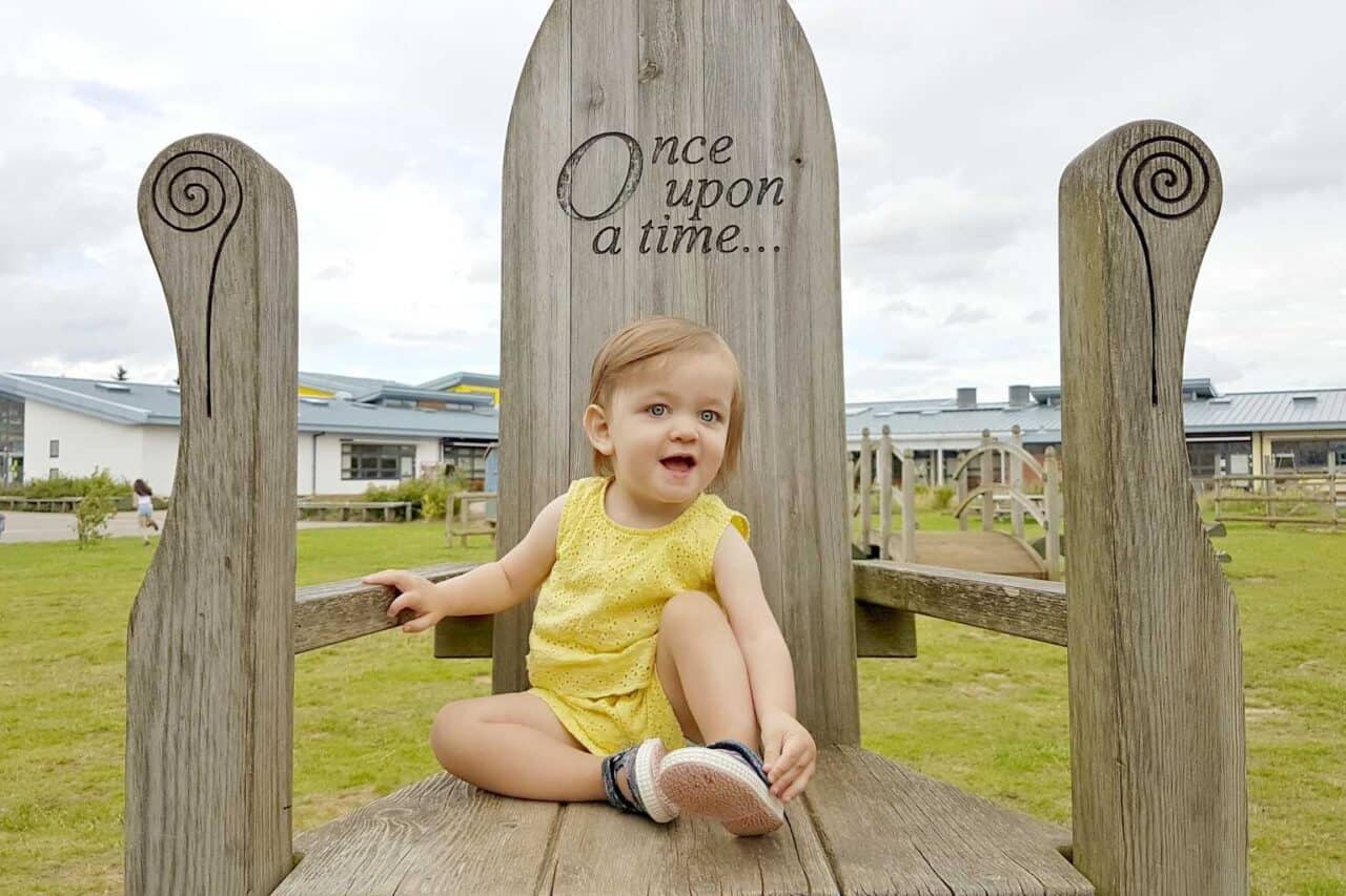 A little girl sitting on a bench