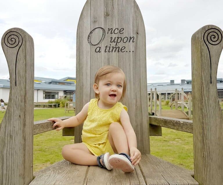 A little girl sitting on a bench