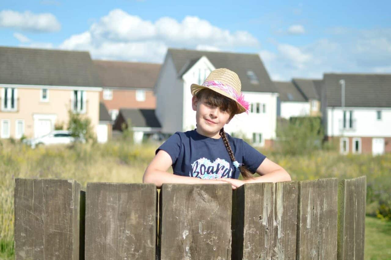 A young boy sitting on a wooden bench