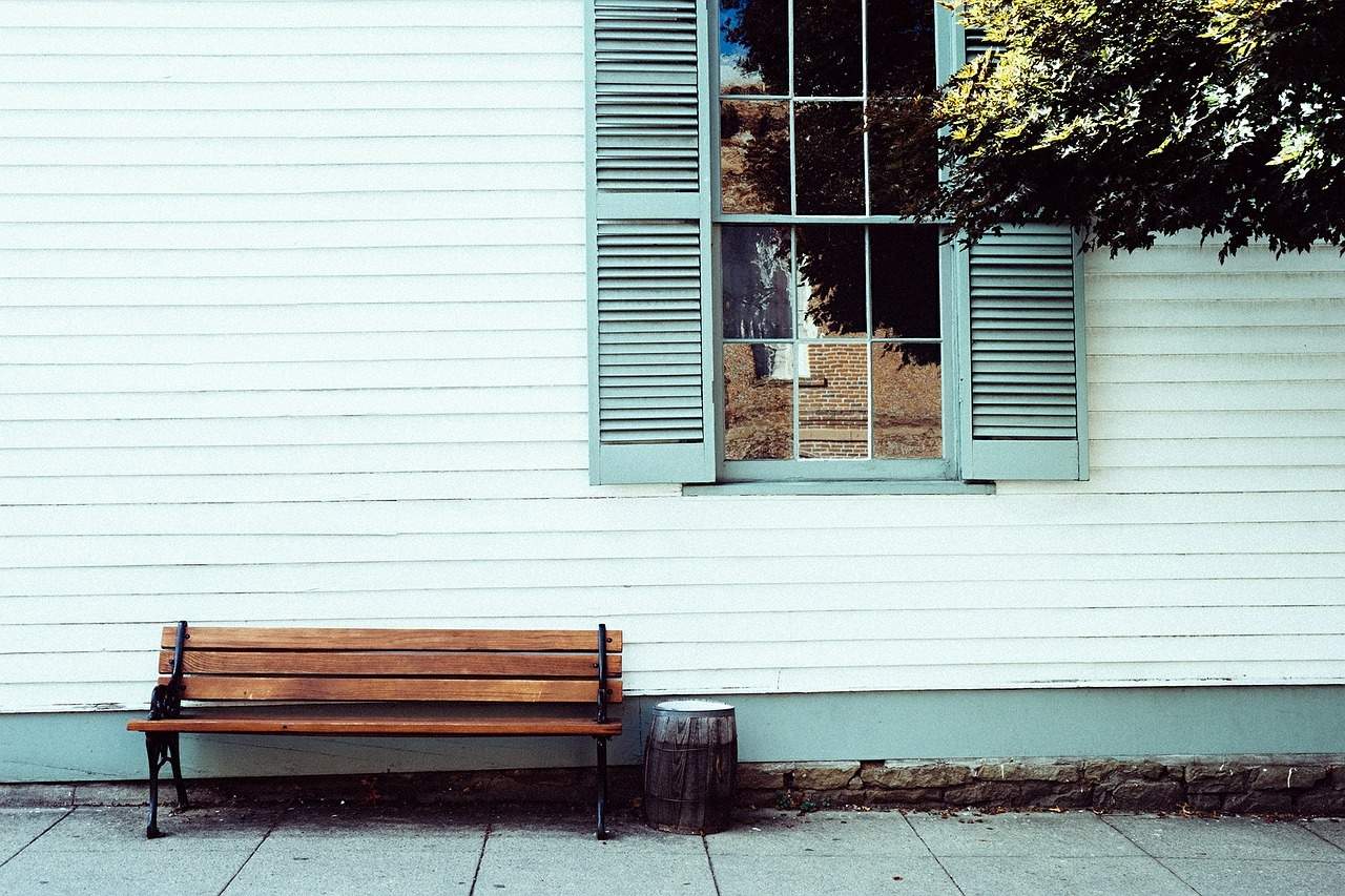 A wooden bench sitting in front of a building
