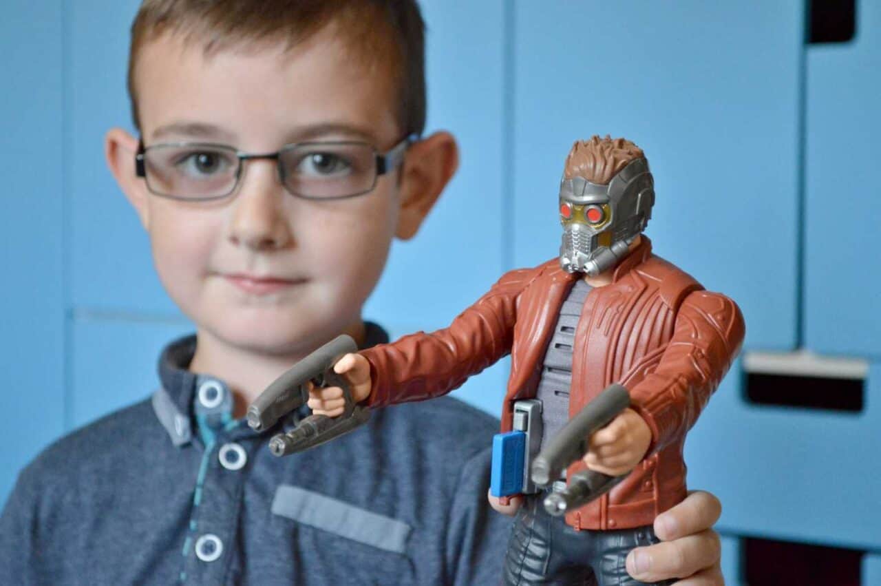 A boy wearing glasses and smiling at the camera, with Tigger and Roo