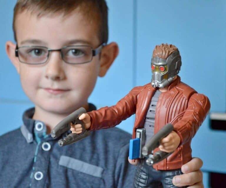 A boy wearing glasses and smiling at the camera, with Tigger and Roo