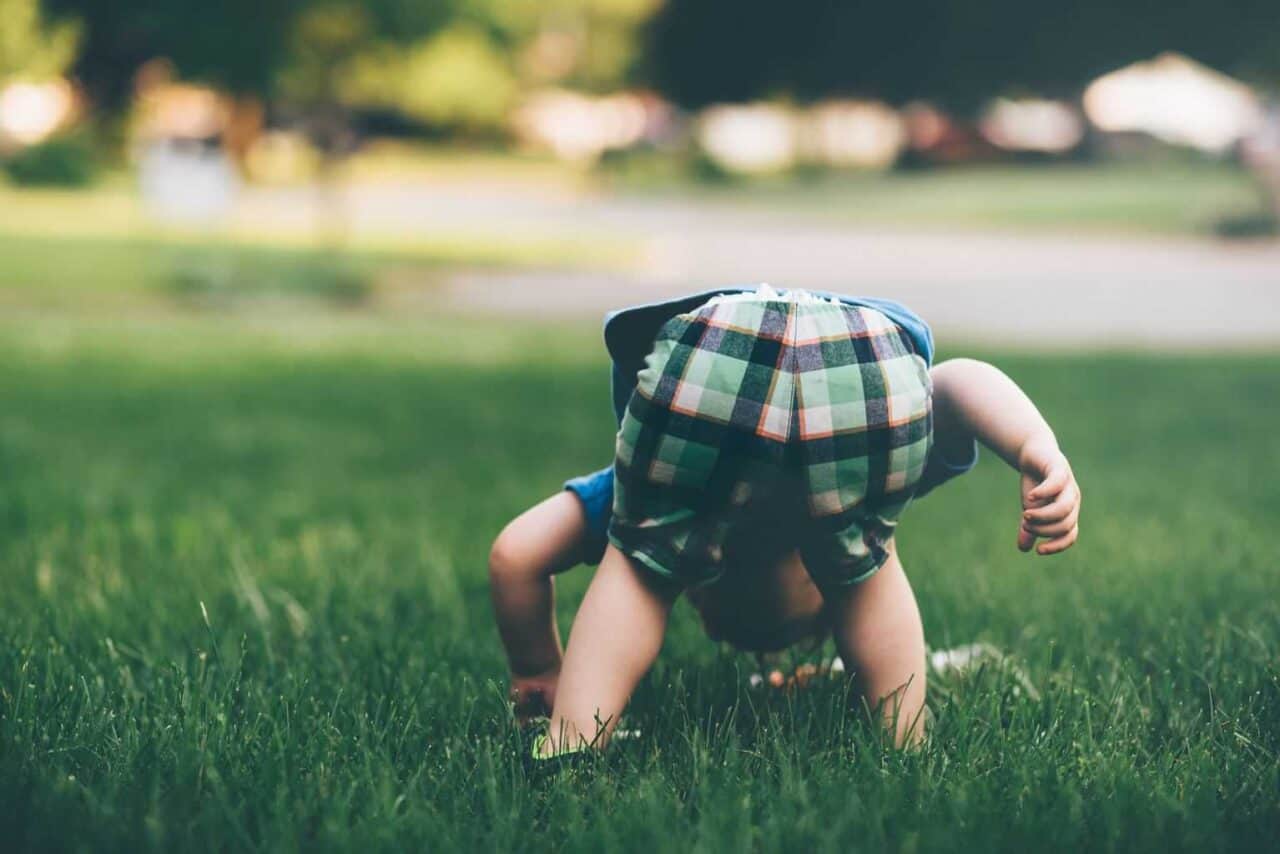 A little girl that is sitting in the grass