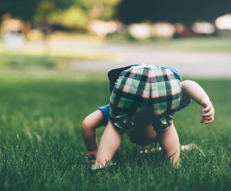 A little girl that is sitting in the grass