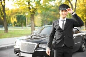 A man wearing a suit and tie standing next to a car