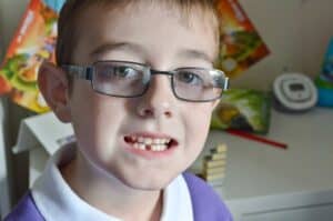 A close up of a child wearing glasses, with Tigger and Roo