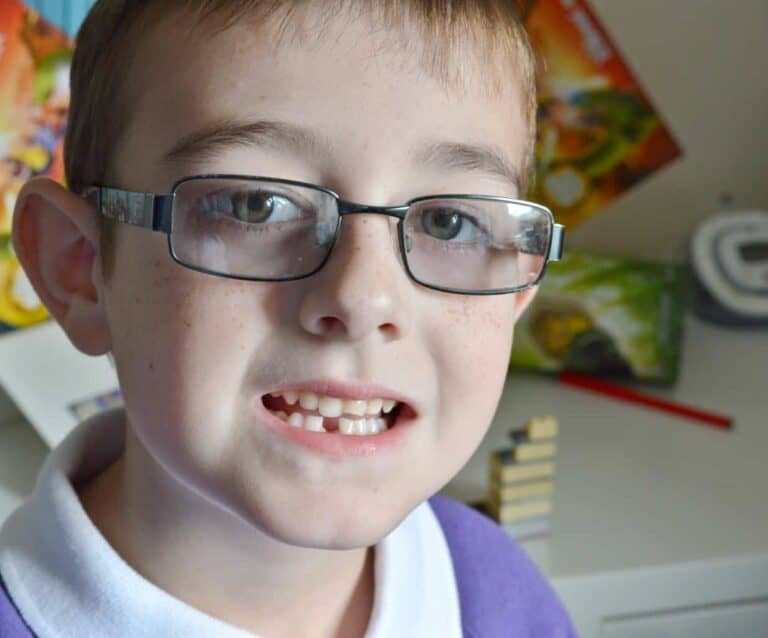 A close up of a child wearing glasses, with Tigger and Roo