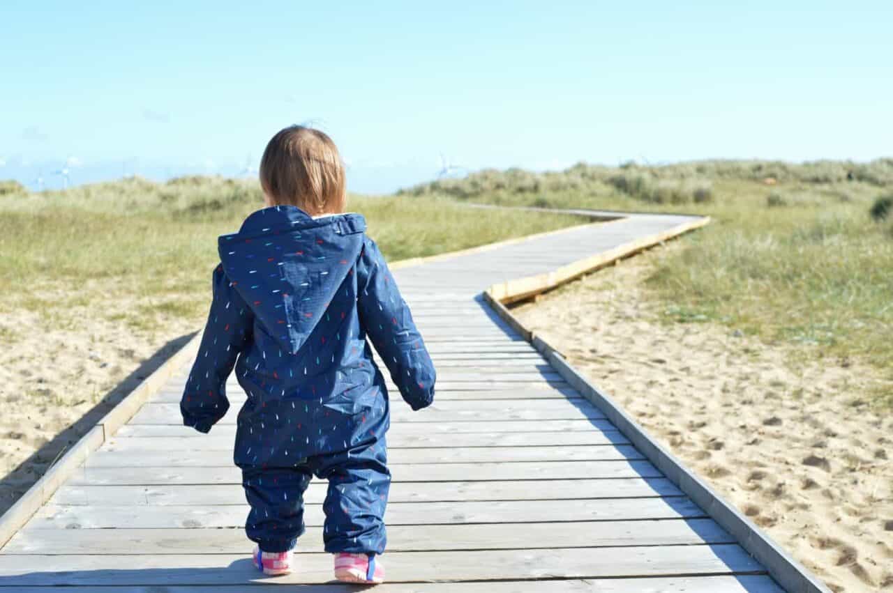 A little boy that is standing in the sand