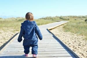 A little boy that is standing in the sand